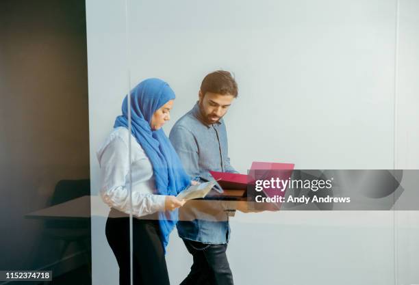 colleagues walking in corridor discussing a project - indian religion and belief stock pictures, royalty-free photos & images