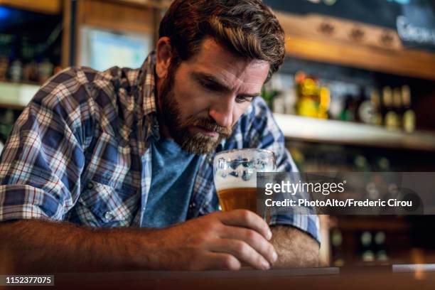 sad man sitting in beer bar - delusione foto e immagini stock
