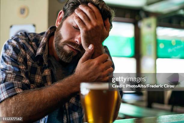 sad man sitting in bar - bar man t shirt stock-fotos und bilder