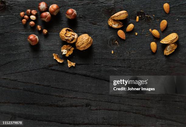 nuts on black background - walnuts stock pictures, royalty-free photos & images