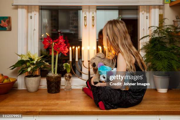 girl sitting on kitchen cupboard - kandelaar stockfoto's en -beelden