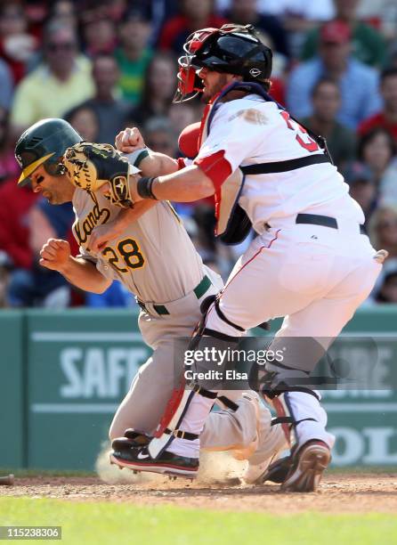 Conor Jackson of the Oakland Athletics is tagged out by Jarrod Saltalamacchia of the Boston Red Sox in the 11th inning on June 4, 2011 at Fenway Park...