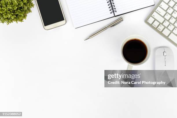 directly above shot of office desk and stationery on white background - office work flat lay stock-fotos und bilder