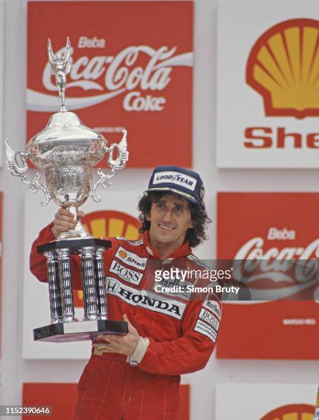 Alain Prost of France, driver of the Honda Marlboro McLaren McLaren MP4/4 Honda V6 turbo celebrates with the trophy after winning the Brazilian Grand...