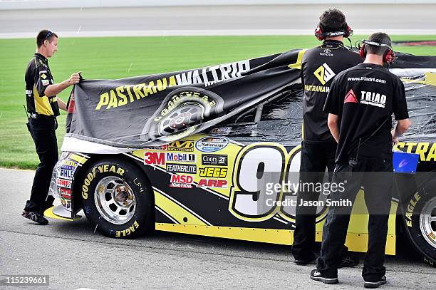 Crew members for Ryan Truex ,, work to the cover the Pastrana Waltrip Racing Toyota, during qualifying for the NASCAR Nationwide Series STP 300 at...
