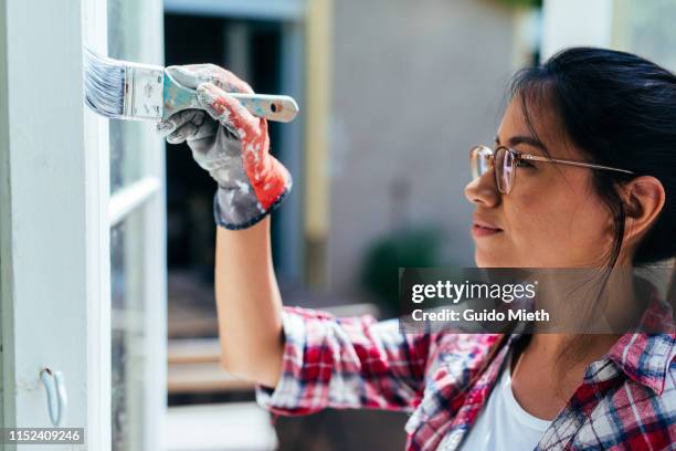 portrait of woman painting garden house. - painting house exterior stock pictures, royalty-free photos & images