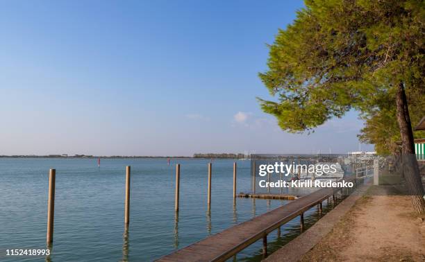 pier in the lagoon on a calm evening - bibione stock pictures, royalty-free photos & images