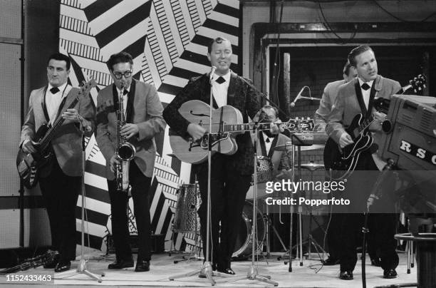 American rock and roll musician Bill Haley performs on stage with The Comets on the set of the music television show Ready Steady Go! at the...