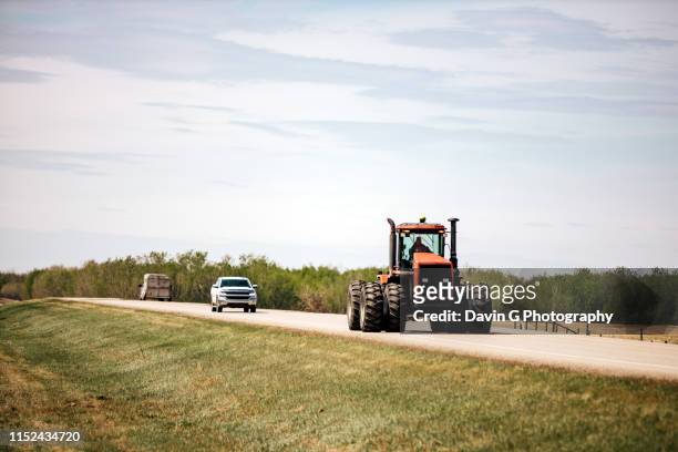 tractor on highway - alberta farm scene stockfoto's en -beelden