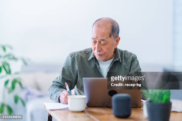 Hombre mayor activo que trabaja en el ordenador portátil en casa