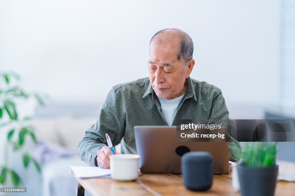Active senior man working on laptop at home