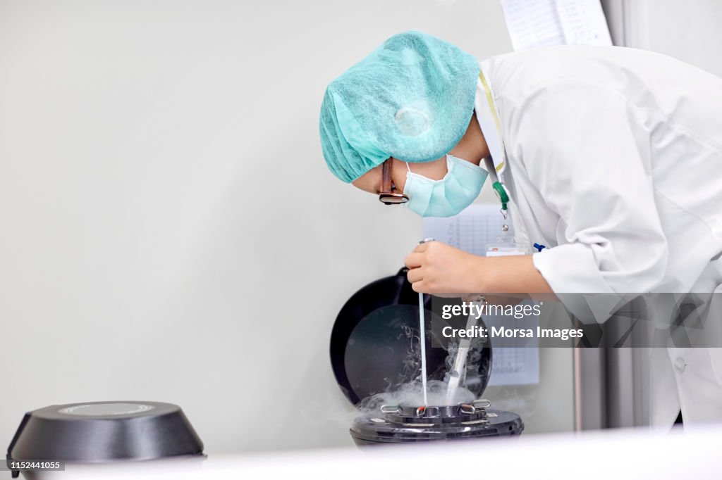 Scienziato che maneggia campioni per la crioconservazione
