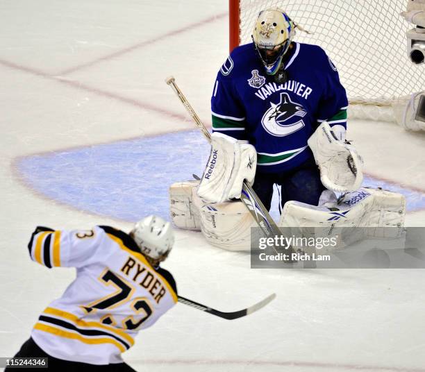 Roberto Luongo of the Vancouver Canucks gets hit in the face mask by a puck shot by Michael Ryder of the Boston Bruins during Game Two of the 2011...