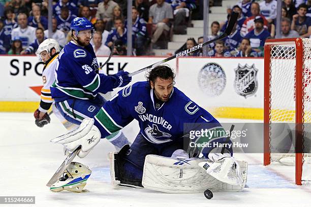 Roberto Luongo of the Vancouver Canucks makes a save after getting hit in the face mask by a puck shot by Michael Ryder of the Boston Bruins during...