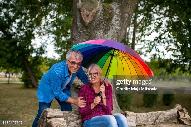 the old couple in the rain with umbrellas - park man made space stock pictures, royalty-free photos & images