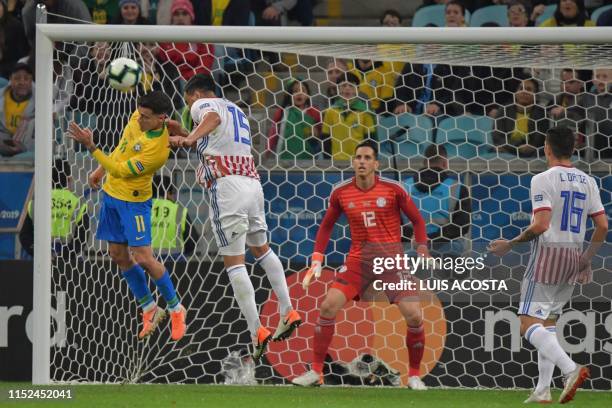 Brazil's Philippe Coutinho and Paraguay's Gustavo Gomez jump for the ball as Paraguay's goalkeeper Roberto Fernandez loosk on during their Copa...