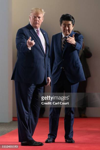 President Donald Trump and Japan's Prime Minister, Shinzo Abe, gesture towards Ivanka Trump and Jared Kushner to join them for a group photograph on...