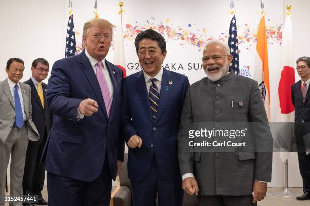 President Donald Trump jokes to the media about fist bumping with Japan's Prime Minister, Shinzo Abe, and India's Prime Minister, Narendra Modi,...