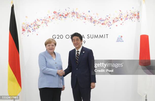 Japanese Prime Minister Shinzo Abe and German Chancellor Angela Merkel at their bilateral meeting on the first day of the G20 summit on June 28, 2019...