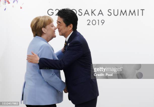 Japanese Prime Minister Shinzo Abe and German Chancellor Angela Merkel at their bilateral meeting on the first day of the G20 summit on June 28, 2019...
