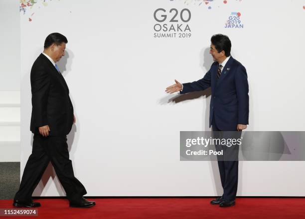 Chinese President Xi Jinping welcomed by Japanese Prime Minister Shinzo Abe for a family photo session on the first day of the G20 summit on June 28,...