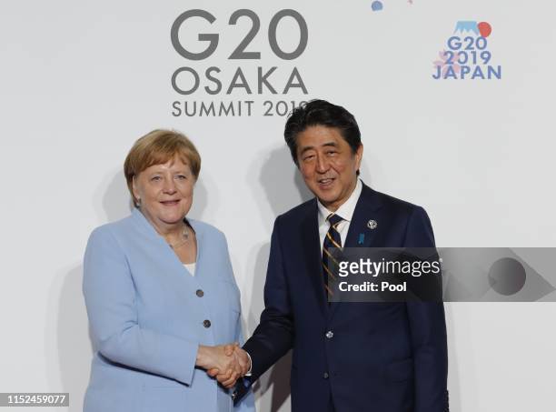 German Chancellor Angela Merkel welcomed by Japanese Prime Minister Shinzo Abe for a family photo session on the first day of the G20 summit on June...
