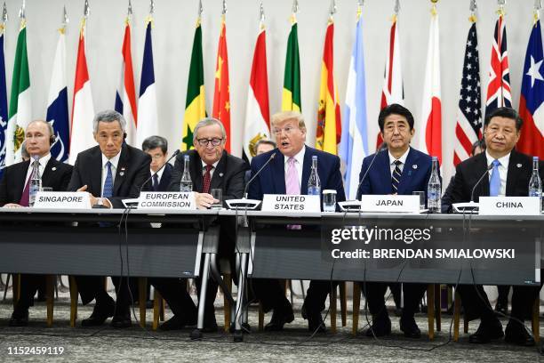 President Donald Trump, Japan's Prime Minister Shinzo Abe and China's President Xi Jinping attend a meeting at the G20 Summit in Osaka on June 28,...