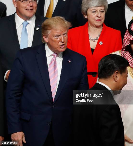 President Donald Trump speaks to Chinese President Xi Jinping after they shake hands at a family photo session at G20 summit on June 28, 2019 in...