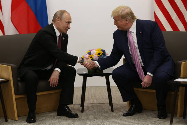 President Donald Trump greets Russian President Vladimir Putin during their bilateral meeting at the G20 Osaka Summit 2019, in Osaka, Japan, June...
