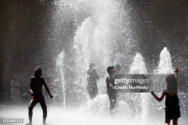 Children play in water jets in a public fountain in Toulouse during the heatwave. An intense heatwave is on Western europe, particulary France....