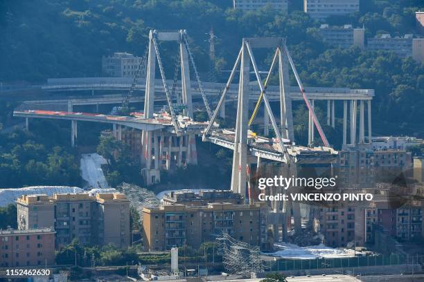 General view shows the remaining eastern pylons of Genoa's Morandi motorway bridge, which are to be destroyed with explosives, seen in red on the...