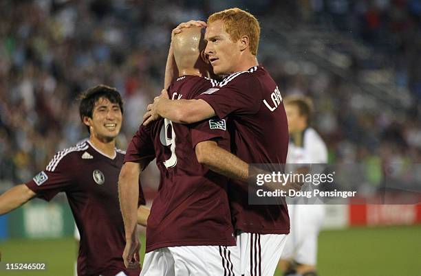 Conor Casey of the Colorado Rapids celebrates his goal with Jeff Larentowicz and Kosuke Kimura of the Rapids on a penalty shot against the...