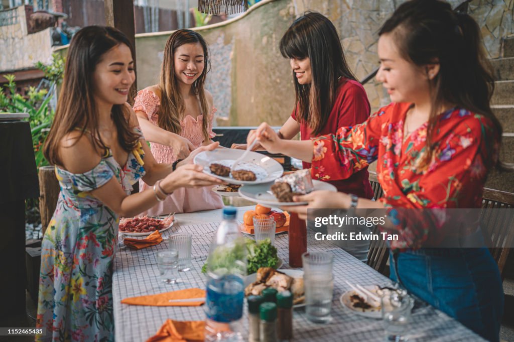 En grupp asiatiska multi etik kvinnliga städa upp rätter efter fest