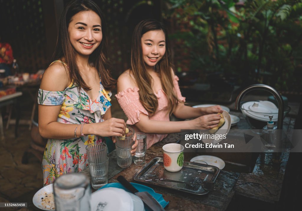 A group of asian chinese ladies cleaning dishes after dinner party at the kitchen