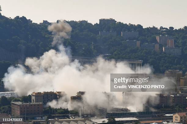 Cloud of smoke covers the site after explosive charges blew up the eastern pylons of Genoa's Morandi motorway bridge on June 28, 2019 in Genoa. -...