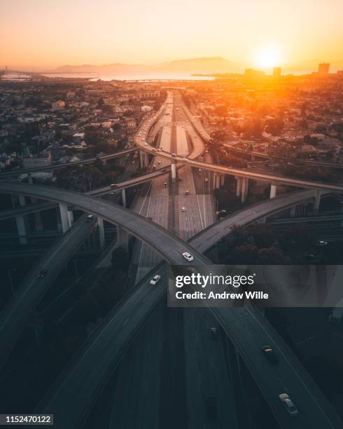 golden sunrise over a busy overpass in oakland, ca - voie urbaine photos et images de collection