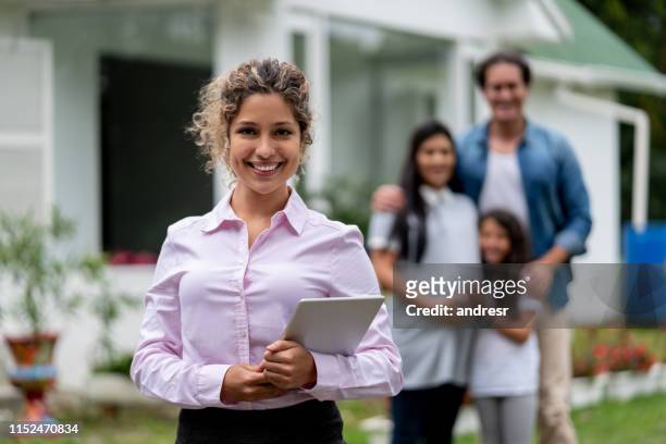 real estate agent showing a family a suburb house - television host stock pictures, royalty-free photos & images