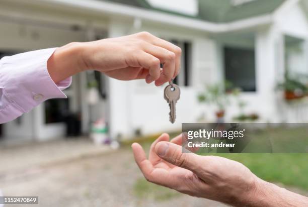 real estate agent giving the keys of a beautiful house - television host stock pictures, royalty-free photos & images