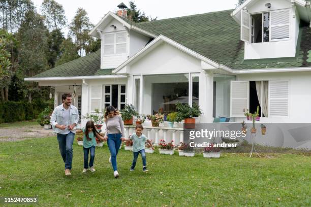 happy family playing outside their new house - rural scene stock pictures, royalty-free photos & images