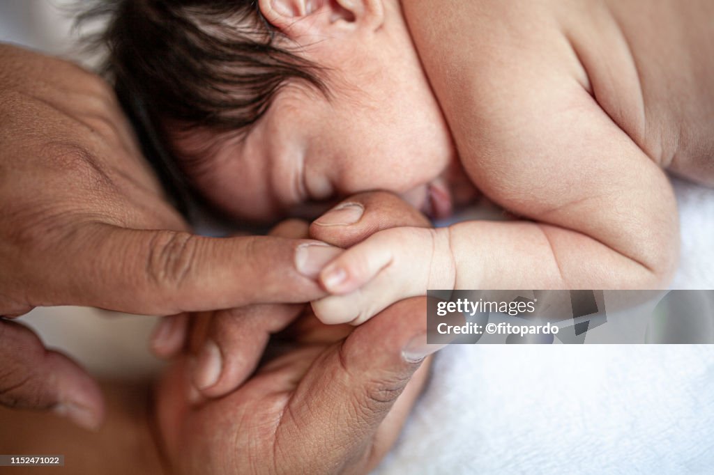 Father holding hands of his baby