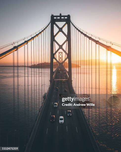 san francisco bay bridge centered with a few cars driving past - bay bridge stock pictures, royalty-free photos & images