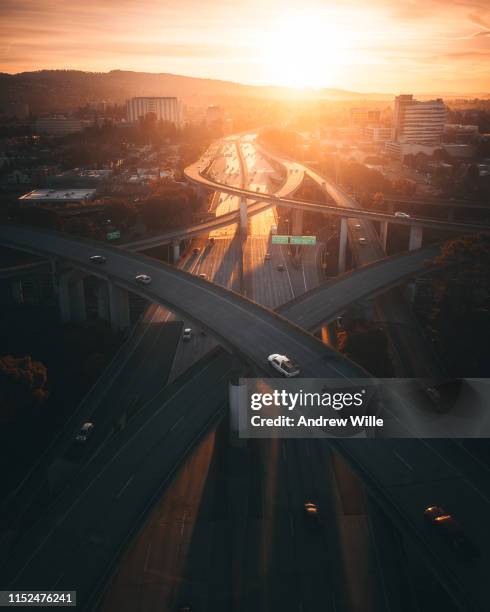 golden sunrise over a busy overpass in oakland, ca - solar street light stock pictures, royalty-free photos & images