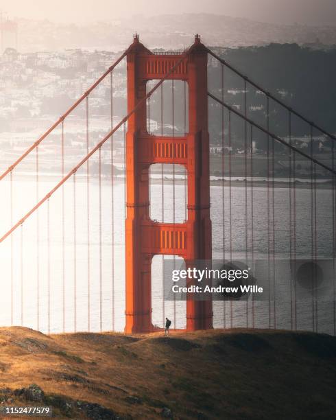 man standing between the golden gate bridge during sunrise - marin headlands fotografías e imágenes de stock