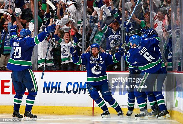 Alex Burrows celebrates with teammates Manny Malhotra, Sami Salo Daniel Sedin and Alexander Edler of the Vancouver Canucks after he scores the game...