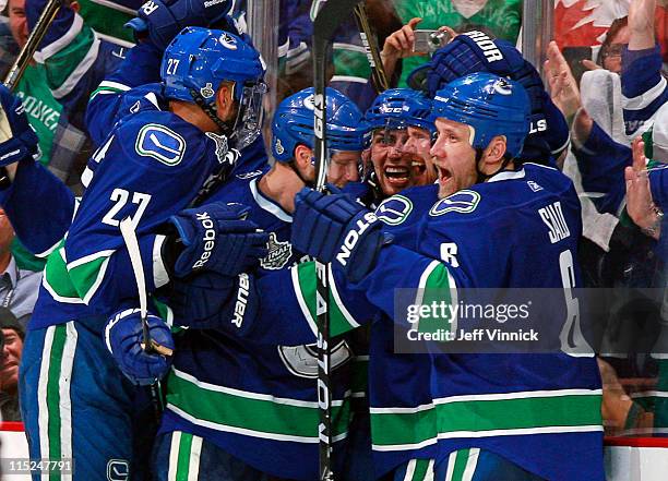 Alex Burrows celebrates with teammates Manny Malhotra, Sami Salo Daniel Sedin and Alexander Edler of the Vancouver Canucks after he scores the game...
