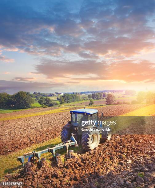 tractor ploegen op het veld - tractor stockfoto's en -beelden