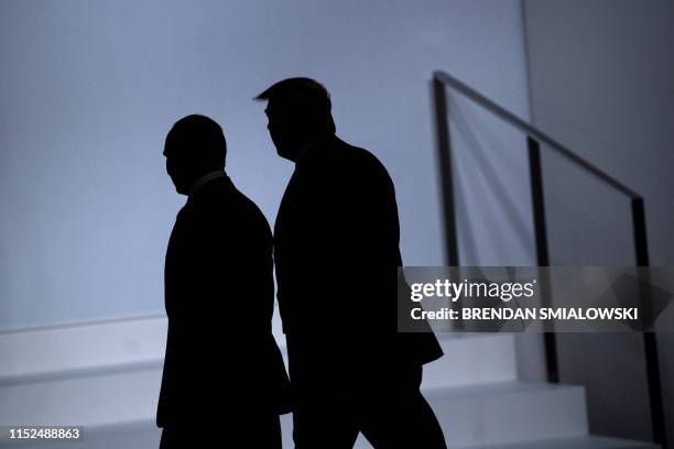 Russia's President Vladimir Putin and US President Donald Trump arrive for a group photo at the G20 Summit in Osaka on June 28, 2019.