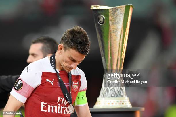 Laurent Koscielny of Arsenal looks dejected as he walks past the Europa League Trophy whilst coduring the UEFA Europa League Final between Chelsea...