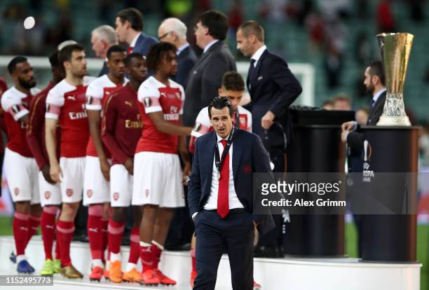 Unai Emery, Manager of Arsenal looks dejected as he walks past the Europa League Trophy after collecting his runners up medal following his team's...