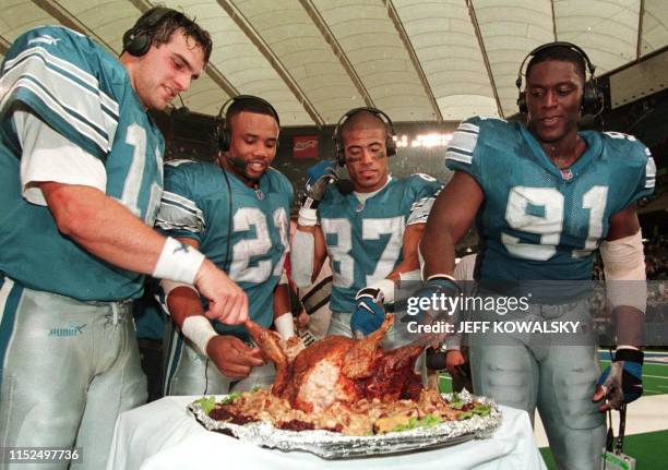 Detroit Lions from left Gus Frerotte , Greg Hill, Johnnie Morton and Robert Porcher get to sample FOX TV's Jon Madden's surgically altered turkey...